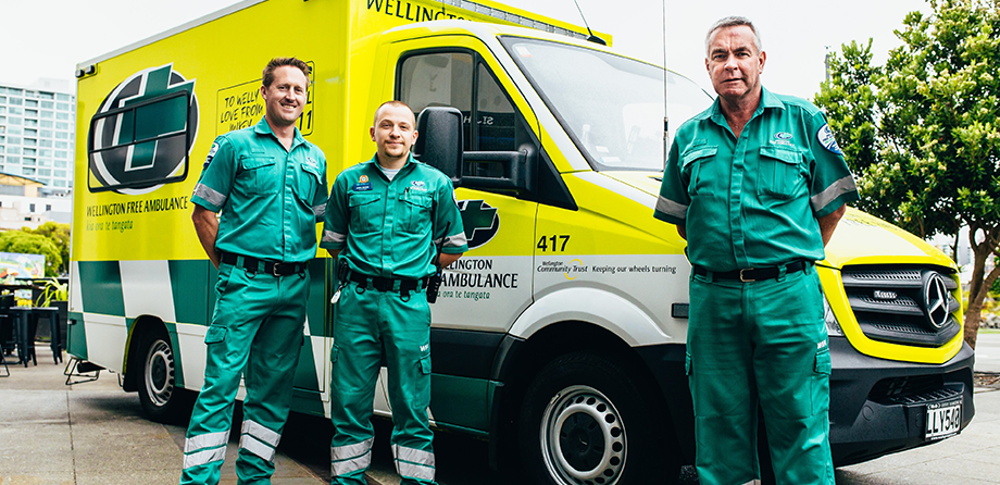 Three paramedics standing in front of an ambulance