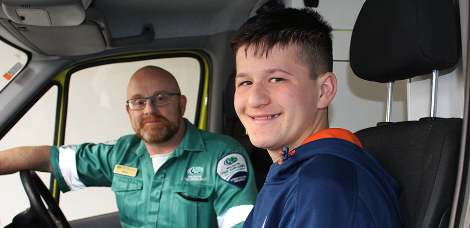 Paramedic and boy smiling at camera