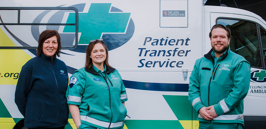 Patient Transfer Service staff in front of one of our ambulances.