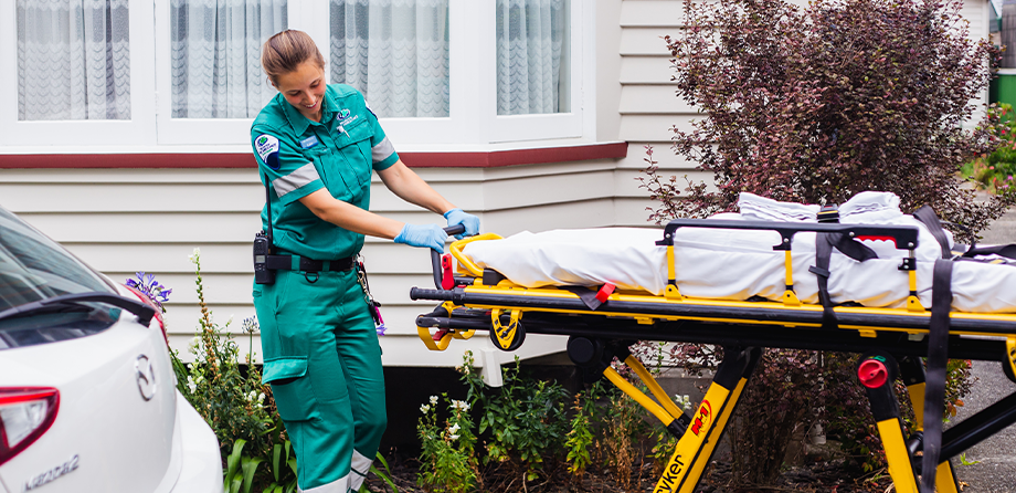 Paramedic Katie pulling a stretcher.