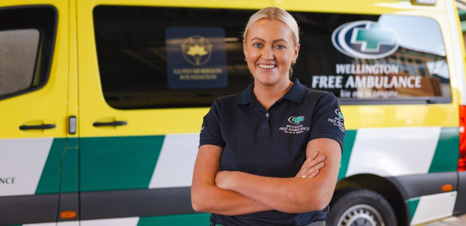 A paramedic crosses her arms and smiles