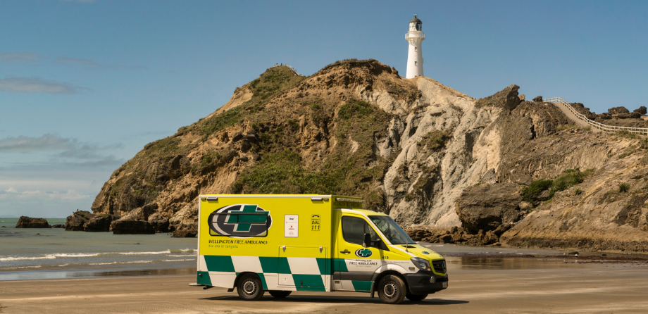A Wellington Free ambulance on a beach in front of Castlepoint, Wairarapa