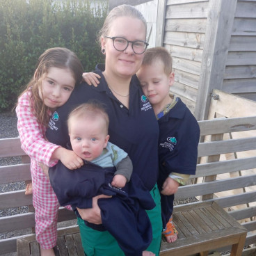 A woman holds her 3 children