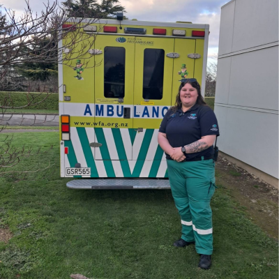A paramedic stands in front of an ambulance