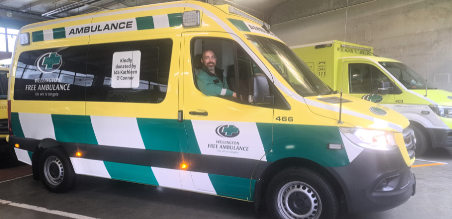 A paramedic smiles from behind the wheel of a new van ambulance