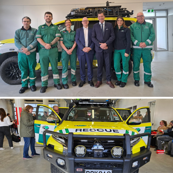 A group of people stand in front of a rescue vehicle