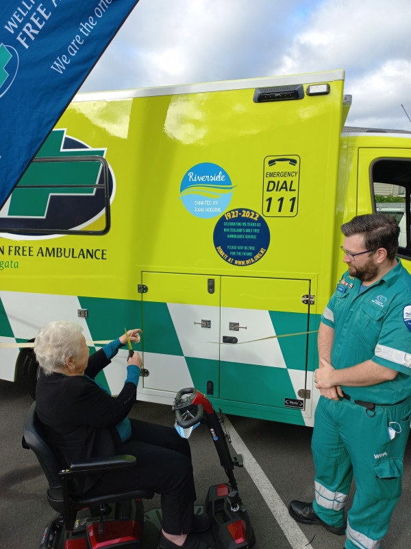 Joan cuts the ribbon to launch new ambulance