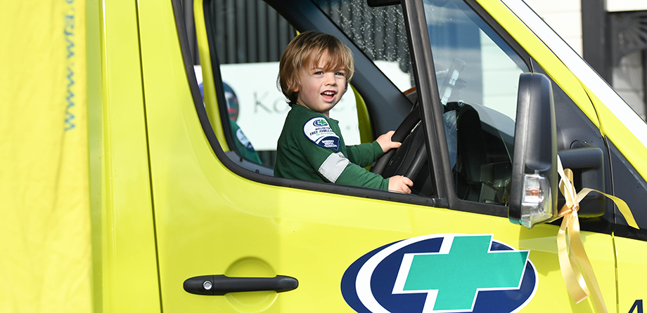 Little boy in ambulance drivers seat smiling
