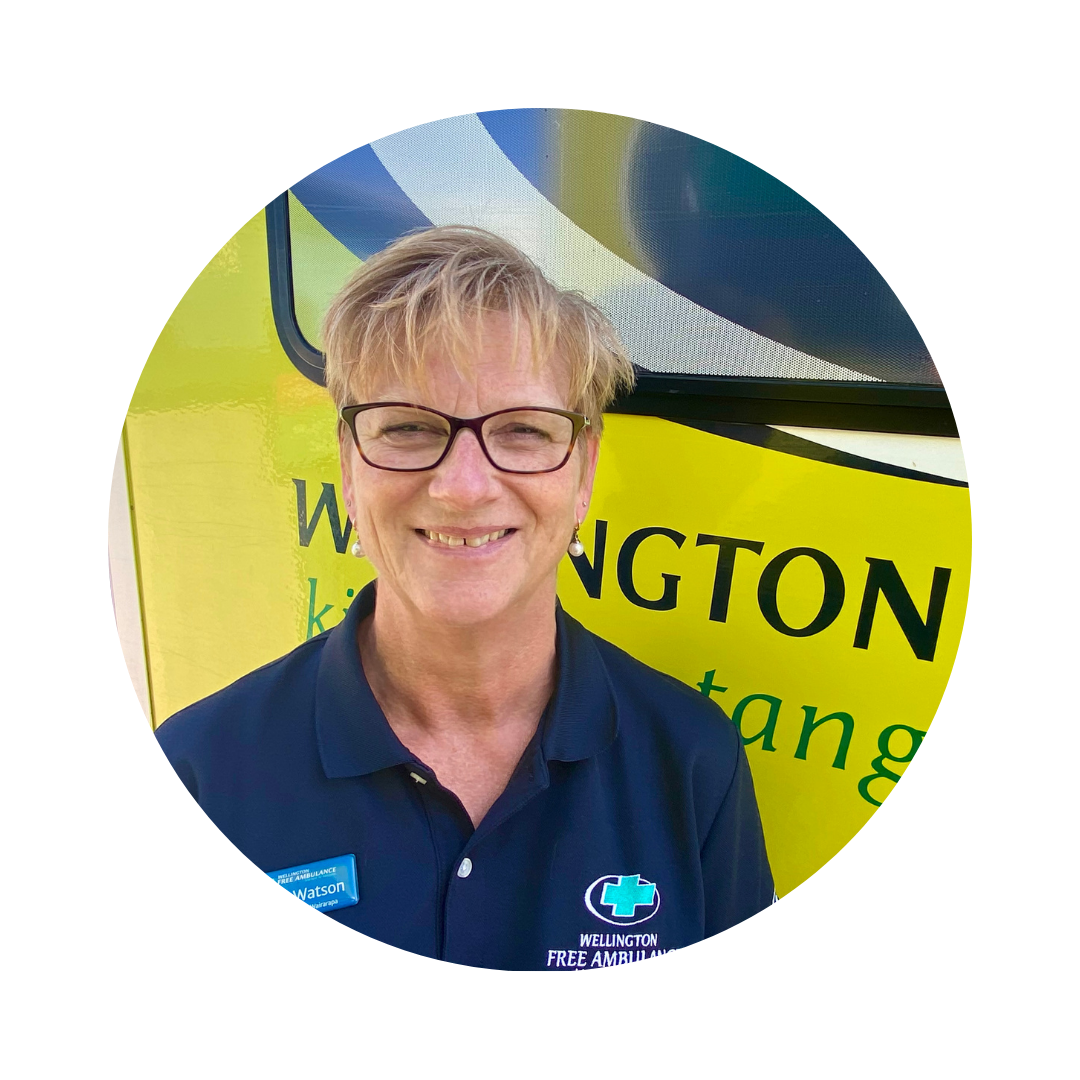A woman in glasses and a dark blue polo shirt smiles