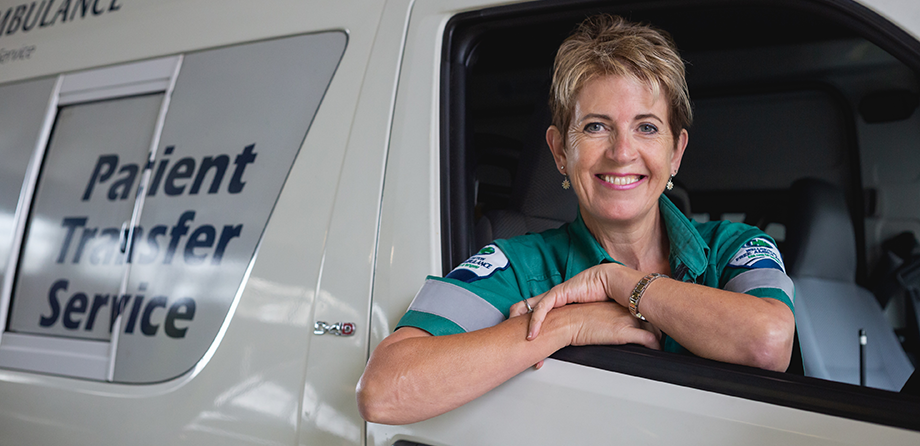 Patient transfer officer sitting in vehicle and smiling at camera